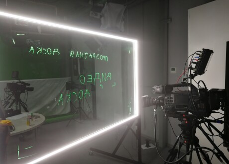 видеокамера в студии с прозрачной светящейся доской